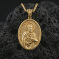 Load image into Gallery viewer, Gold plated Saint Peter pendant necklace presented on porous volcanic rock, highlighting the oval medallion form and sacred devotional design in a luxurious close-up jewelry image.