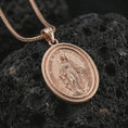 Load image into Gallery viewer, Rose gold plated Miraculous Medal pendant necklace on dark volcanic rock, photographed in a detailed premium studio macro view.