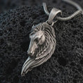 Load image into Gallery viewer, Sterling silver Pegasus wing horse pendant necklace with an oxidized finish resting on textured volcanic rock, captured in a close-up premium studio composition.