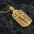 Load image into Gallery viewer, Gold plated Jesus INRI crucifixion pendant necklace presented on porous volcanic rock, highlighting the rectangular devotional form in a luxurious close-up jewelry image.