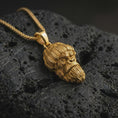 Load image into Gallery viewer, Gold plated gorilla head pendant necklace presented on porous volcanic rock, highlighting the bold street-inspired ape motif in a luxurious close-up jewelry image.