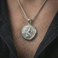 Load image into Gallery viewer, Polished silver lion medallion pendant necklace worn on the neck, presented in a clean close-up model image with an elegant and commanding masculine look.