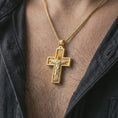 Load image into Gallery viewer, Gold plated Cristo Protetor cross pendant necklace worn on the neck, captured on a human model in a premium dark-toned lifestyle frame.