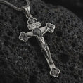 Load image into Gallery viewer, Sterling silver crucifix pendant necklace with an oxidized finish displayed on black volcanic stone, captured in a close-up studio image highlighting the detailed Jesus figure and floral cross tips.