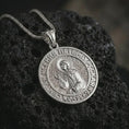 Load image into Gallery viewer, Polished silver Saint Xenia pendant necklace resting on dark volcanic rock, shown in a premium close-up image that highlights the sacred Orthodox saint figure and circular devotional design.