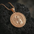 Load image into Gallery viewer, Rose gold plated Saint Xenia pendant necklace photographed on porous volcanic stone, showcasing the Saint Ksenia icon, ornamental border, and refined spiritual craftsmanship.