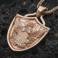 Load image into Gallery viewer, Rose gold plated Fortiores Una eagle shield pendant necklace on dark volcanic rock, photographed in a detailed premium studio macro view.