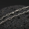 Load image into Gallery viewer, Sterling silver cable link chain necklace with an oxidized finish resting on textured volcanic rock, captured in a close-up premium studio composition.