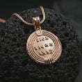Load image into Gallery viewer, Rose gold plated Emperor Constans coin pendant necklace presented on textured volcanic stone, showcasing the round Roman coin silhouette and refined emperor relief in a macro studio shot.