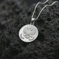 Load image into Gallery viewer, Polished silver heraldic eagle coin pendant necklace displayed on dark volcanic rock, shown in a premium close-up image that highlights the imperial double-headed eagle motif and antique coin-style detailing.