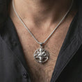 Load image into Gallery viewer, Polished silver Baphomet goat head pendant necklace worn on the neck, shown against the chest in a clean and dramatic everyday wear composition.