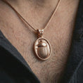 Load image into Gallery viewer, Rose gold plated Egyptian scarab pendant necklace worn on the neck, presented in a close-up lifestyle shot with a refined symbolic aesthetic.