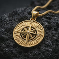 Load image into Gallery viewer, Gold plated compass rose pendant necklace presented on porous volcanic rock, highlighting the round explorer medallion design in a luxurious close-up jewelry image.