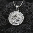 Load image into Gallery viewer, Polished silver Emperor Augustus coin pendant necklace displayed on dark volcanic rock, shown in a premium close-up image that highlights the classical emperor portrait and antique Roman coin texture.