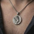 Load image into Gallery viewer, Oxidized Nefertiti medallion pendant necklace worn on the neck, styled in a dark lifestyle portrait with an open shirt and elegant presentation.