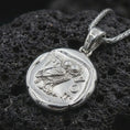 Load image into Gallery viewer, Polished silver Athena owl coin pendant necklace displayed on dark volcanic rock, shown in a premium close-up image that highlights the sacred owl motif and antique coin texture.