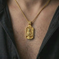 Load image into Gallery viewer, Gold plated Joan of Arc dog tag pendant necklace worn on the neck, captured in a premium lifestyle composition that highlights the Catholic warrior saint motif as a meaningful Christian statement piece.