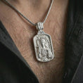 Load image into Gallery viewer, Polished silver Saint Barbara pendant necklace worn on the chest, masculine lifestyle shot highlighting the saint relief, cross, tower detail, and bright silver finish.