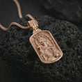 Load image into Gallery viewer, Rose gold plated Saint Barbara pendant necklace on textured volcanic rock, detailed macro product shot with soft warm reflections and sacred icon relief.