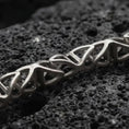 Load image into Gallery viewer, Sterling silver DNA helix chain necklace with an oxidized finish resting on textured volcanic rock, captured in a close-up premium studio composition.
