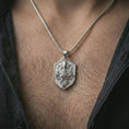 Load image into Gallery viewer, Polished silver kraken octopus shield pendant necklace worn on the neck, shown against the chest in a clean and striking everyday wear composition.