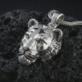 Load image into Gallery viewer, Polished silver 3D lioness pendant necklace displayed on black volcanic rock, shown in a refined macro product shot with realistic feline face sculpting, soft mane detail, and powerful safari-inspired presence.
