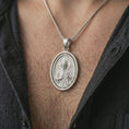 Load image into Gallery viewer, Polished silver Saint Jude pendant necklace worn on the chest, masculine lifestyle shot highlighting the saint relief, halo, medallion detail, and bright silver finish.