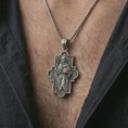 Load image into Gallery viewer, Oxidized Good Shepherd cross pendant necklace worn on the chest, close-up lifestyle jewelry photo showing the Christian cross medallion on a spiga chain with dark clothing.