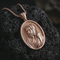 Load image into Gallery viewer, Rose gold plated Jesus Christ Good Shepherd pendant necklace on textured volcanic rock, detailed macro product shot with soft warm reflections and devotional shepherd design.