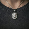 Load image into Gallery viewer, Polished silver bull head shield pendant necklace worn on the neck, shown against the chest in a clean and striking everyday wear composition.