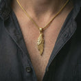 Load image into Gallery viewer, Gold plated raven pendant necklace worn on the neck, captured on a human model in a premium dark-toned lifestyle frame.
