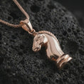 Load image into Gallery viewer, Rose gold plated knight chess piece pendant necklace on dark volcanic rock, photographed in a detailed premium studio macro view.