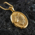 Load image into Gallery viewer, Gold plated wolf medallion pendant necklace presented on porous volcanic rock, highlighting the wild forest guardian motif in a luxurious close-up jewelry image.