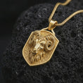 Load image into Gallery viewer, Gold plated ram head shield pendant necklace presented on porous volcanic rock, highlighting the zodiac-inspired animal motif in a luxurious close-up jewelry image.