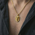 Load image into Gallery viewer, Ram head shield pendant necklace with a gold plated finish worn on the neck, captured in a premium lifestyle composition with the pendant centered on the chest.