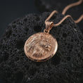 Load image into Gallery viewer, Rose gold plated lion medallion pendant necklace on dark volcanic rock, shown in a premium macro studio view with a bold round medallion silhouette and majestic lion profile.