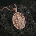 Load image into Gallery viewer, Rose gold plated Saint Barbara pendant necklace on textured volcanic rock, detailed macro product shot with soft warm reflections and devotional Saint Barbara design.