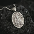 Load image into Gallery viewer, Polished silver Saint Barbara pendant necklace on textured volcanic rock, centered macro jewelry photo with detailed Catholic medal engraving and bright silver highlights.