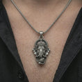 Load image into Gallery viewer, Oxidized Ganesha pendant necklace worn on the chest, close-up lifestyle jewelry photo showing the spiritual talisman on a spiga chain with dark clothing.