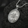 Load image into Gallery viewer, Polished silver spinning Jesus Christ pendant necklace on textured volcanic rock, centered macro jewelry photo with detailed Christian portrait relief and bright silver highlights.