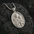 Load image into Gallery viewer, Polished silver Saint Joseph and Jesus pendant necklace on textured volcanic rock, centered macro jewelry photo with detailed Catholic medal engraving and bright silver highlights.