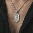 Load image into Gallery viewer, Polished silver Saint Roch dog tag pendant necklace worn on the chest, masculine lifestyle shot highlighting the pilgrim saint relief, staff, dog detail, and bright silver finish.