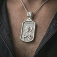 Load image into Gallery viewer, Polished silver Saint Jude dog tag pendant necklace worn on the chest, masculine lifestyle shot highlighting the saint relief, halo, medallion detail, and bright silver finish.