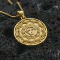Load image into Gallery viewer, Gold plated Manipura chakra pendant necklace on textured volcanic rock, premium close-up studio composition emphasizing the solar plexus chakra symbol and ornate lotus design.