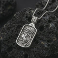 Load image into Gallery viewer, Polished silver crucified Jesus dog tag pendant necklace on textured volcanic rock, centered macro jewelry photo with detailed crown of thorns portrait and bright silver highlights.