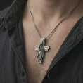 Load image into Gallery viewer, Oxidized Jesus cross pendant necklace worn on the chest, close-up lifestyle jewelry photo showing the religious cross pendant on a spiga chain with dark clothing.