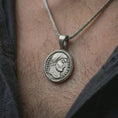 Load image into Gallery viewer, Oxidized Emperor Constans coin pendant necklace worn on the neck, styled in a dark lifestyle image that presents the ancient Roman coin as a bold historical statement piece.