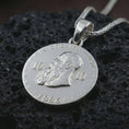 Load image into Gallery viewer, Polished silver heraldic eagle coin pendant necklace displayed on dark volcanic rock, shown in a premium close-up image that highlights the imperial double-headed eagle motif and antique coin-style detailing.