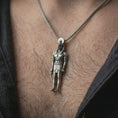 Load image into Gallery viewer, Oxidized Ra amulet pendant necklace worn on the neck, styled in a dark lifestyle image that presents the Egyptian god pendant as a bold symbolic and historical statement piece.
