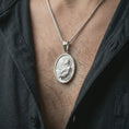 Load image into Gallery viewer, Polished silver Jesus Christ prayer pendant necklace worn on the chest, masculine lifestyle shot highlighting the praying Christ relief, halo, and bright silver finish.